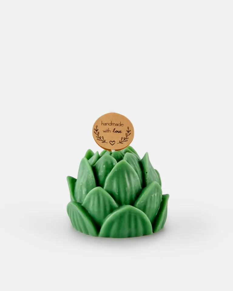 Świeczka sojowa w kształcie zielonej rośliny sukulentowej, ozdobiona małą, okrągłą karteczką z napisem „handmade with love” oraz prostymi rysunkami liści, umieszczona na białym tle.